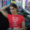 crop top tee mockup being worn by a girl lying on the arcade car games a19440