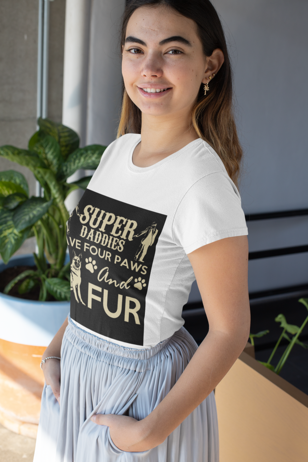 mockup of a woman wearing a t shirt with a customizable sleeve next to a plant 31459