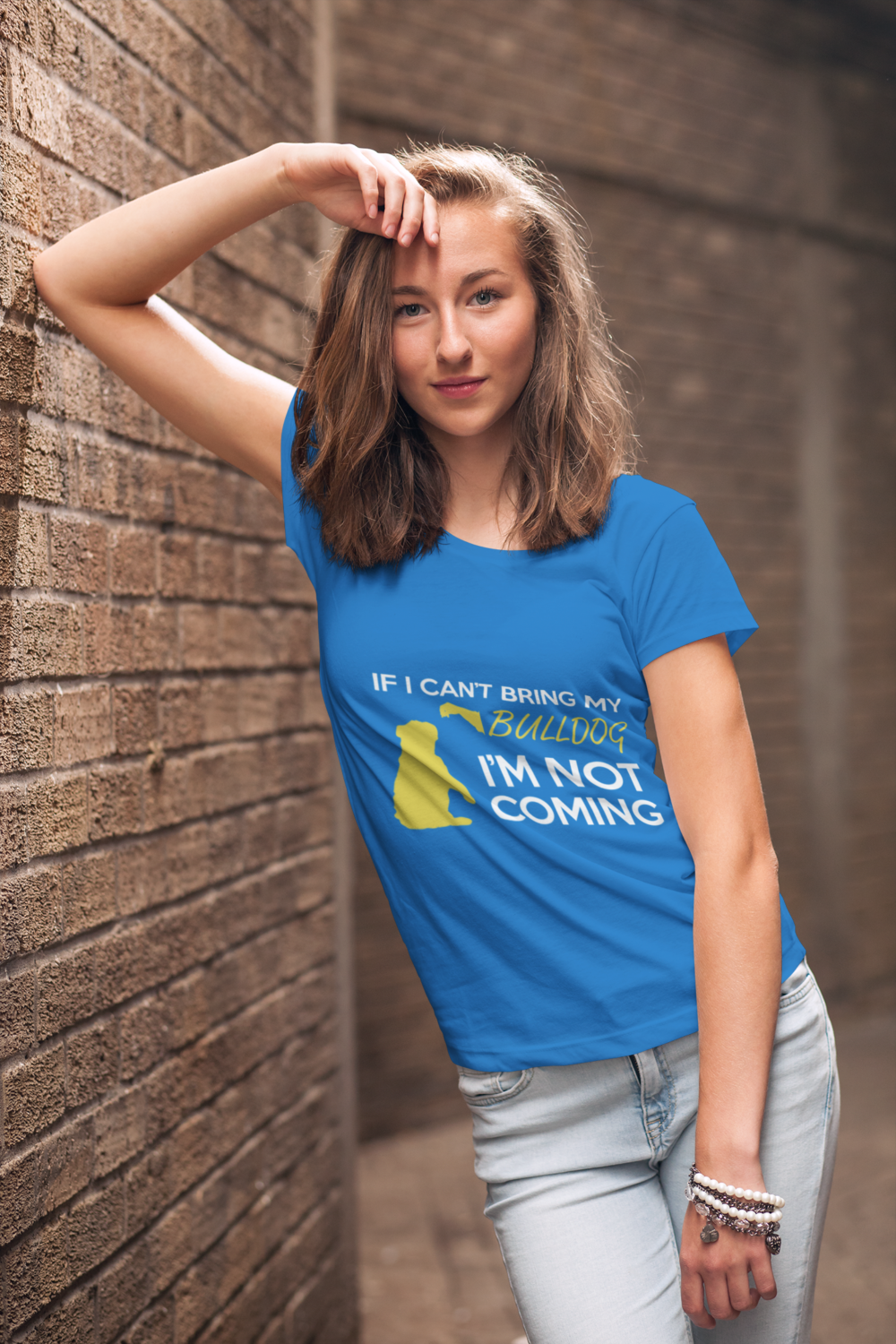 mockup of a young woman wearing a customizable t shirt and leaning against a brick wall 2764 el1