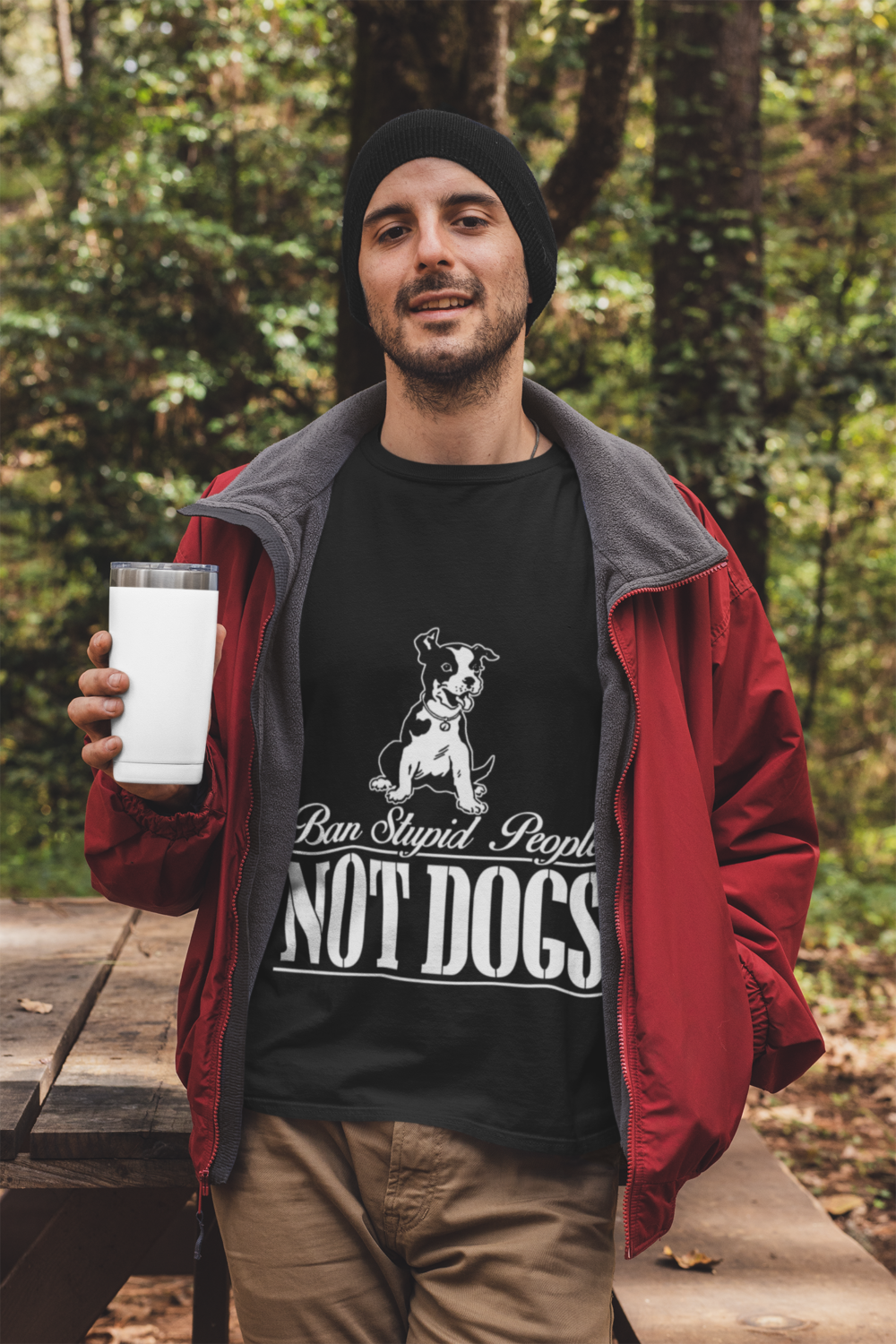 t shirt mockup featuring a man holding a 20 oz travel mug in the woods 30486