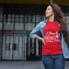 t shirt mockup of a wavy haired woman standing outside a modern building 24662